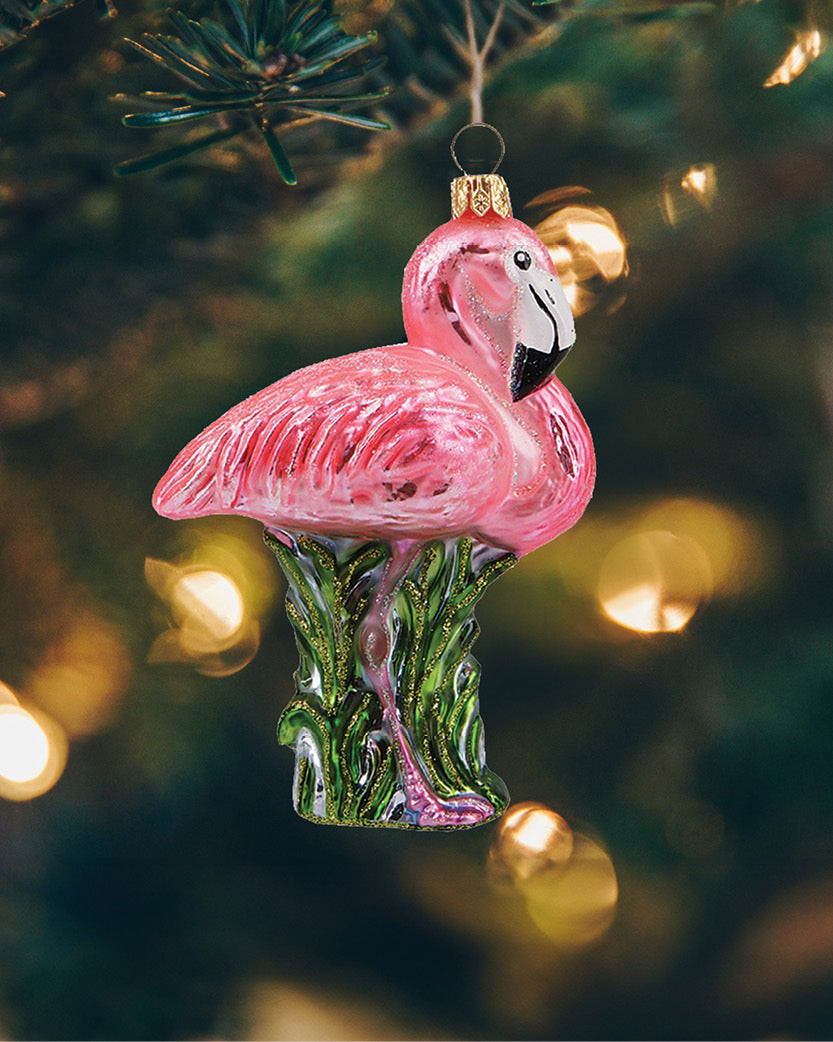 Elegant pink flamingo julekugle, der hænger i et juletræ